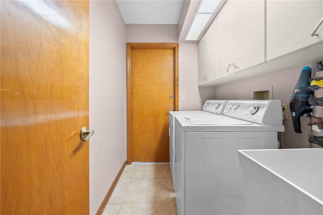 washroom featuring cabinets, separate washer and dryer, sink, and light tile patterned floors