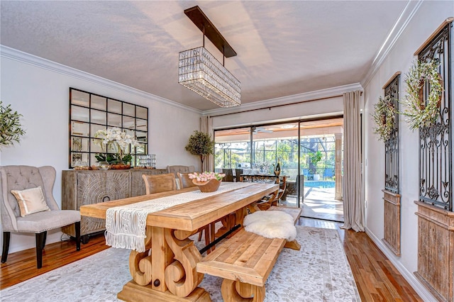 dining space with light hardwood / wood-style flooring and ornamental molding