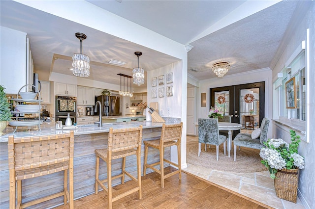 kitchen featuring hanging light fixtures, a breakfast bar, an inviting chandelier, and kitchen peninsula