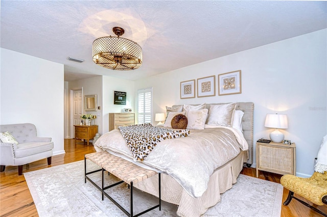 bedroom with hardwood / wood-style flooring and a textured ceiling