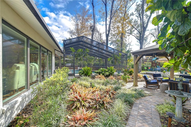 view of yard featuring a gazebo, a patio, and glass enclosure