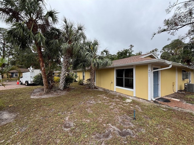 view of property exterior with cooling unit and a yard