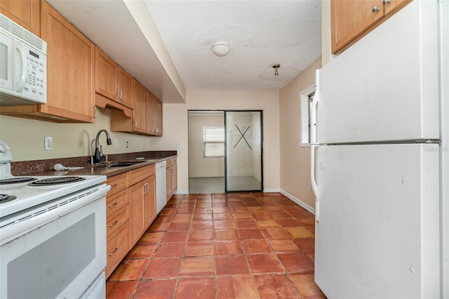 kitchen with white appliances, sink, and a textured ceiling