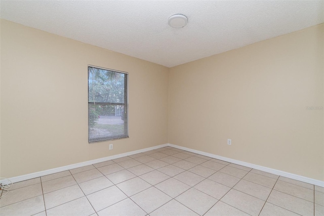 tiled empty room with a textured ceiling