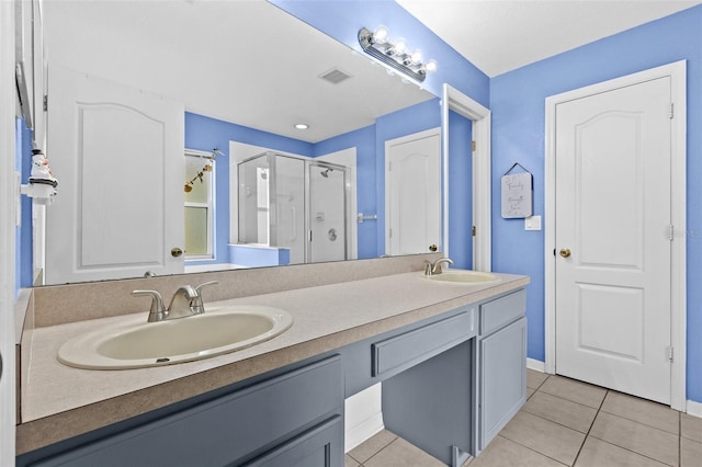 bathroom with tile patterned flooring, vanity, and a shower with door