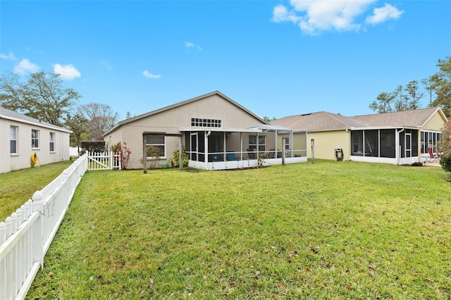 back of house featuring a yard and a sunroom