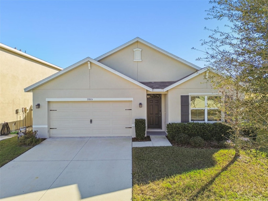 single story home featuring a garage and a front lawn