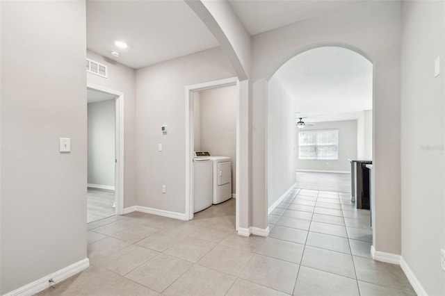 hallway with washer and dryer and light tile patterned flooring