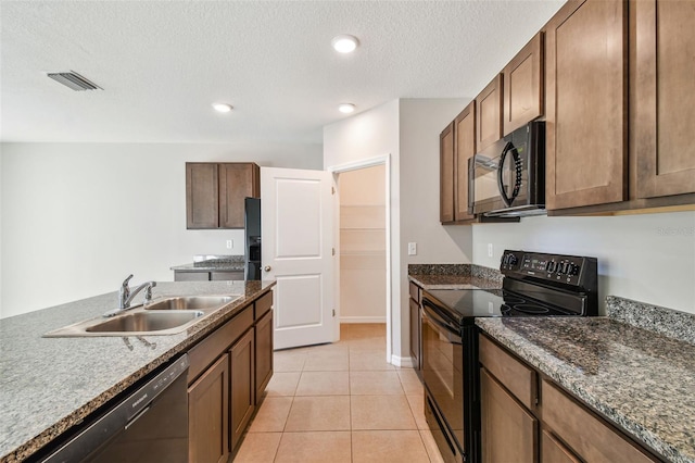 kitchen featuring sink, light tile patterned floors, black appliances, a textured ceiling, and stone countertops