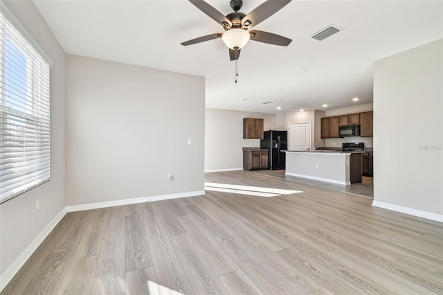 unfurnished living room featuring ceiling fan and light hardwood / wood-style floors