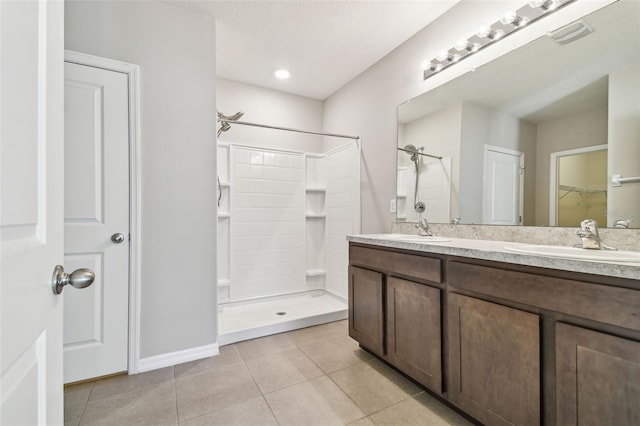 bathroom with tile patterned floors, vanity, and a shower