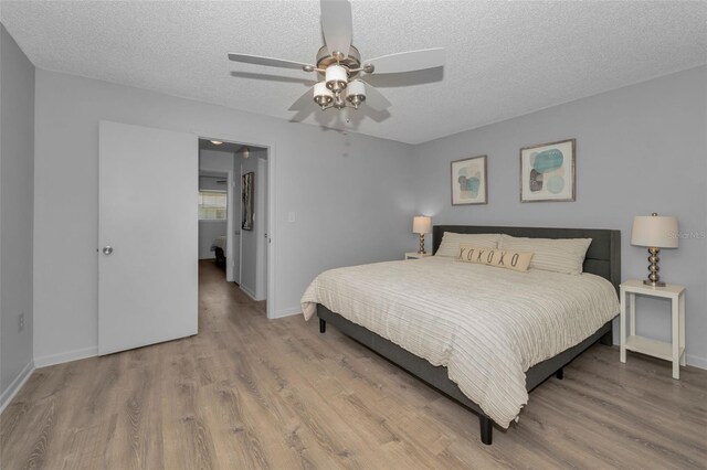 bedroom featuring a textured ceiling, wood finished floors, and baseboards