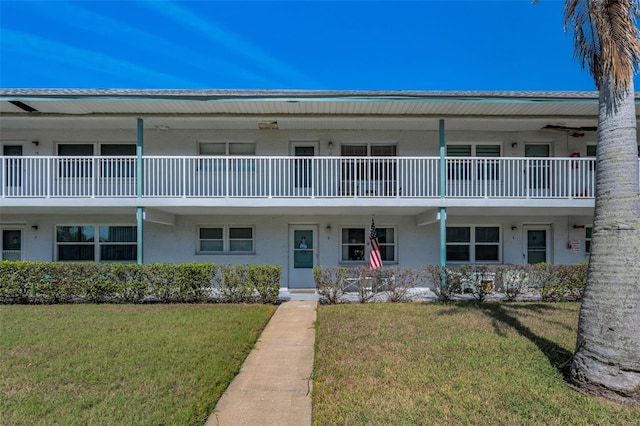 multi unit property with a front lawn and stucco siding