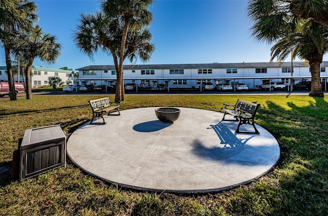 view of community featuring a patio area, a yard, and a fire pit