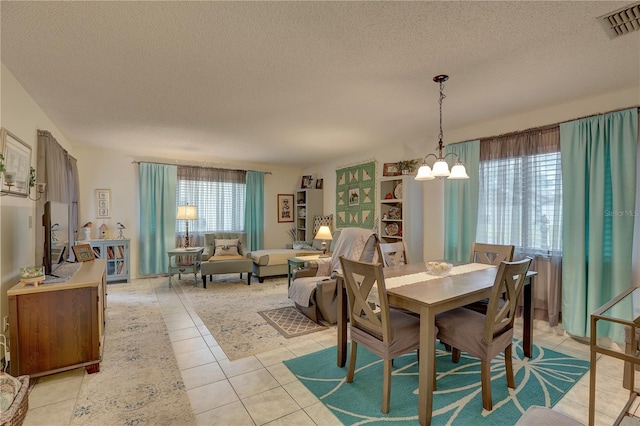 tiled dining area featuring a notable chandelier and a textured ceiling