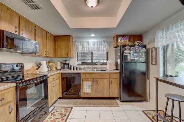 kitchen with sink, light tile patterned floors, and black appliances