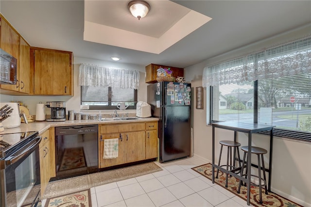 kitchen featuring sink, black appliances, and light tile patterned flooring