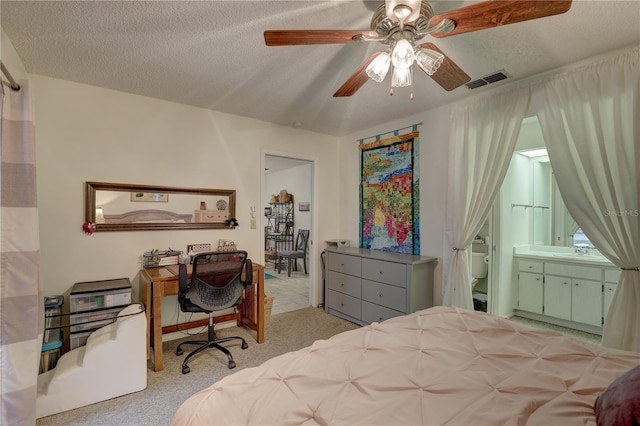 carpeted bedroom with sink, ensuite bath, a textured ceiling, and ceiling fan