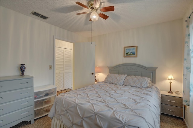 carpeted bedroom featuring a textured ceiling, a closet, and ceiling fan