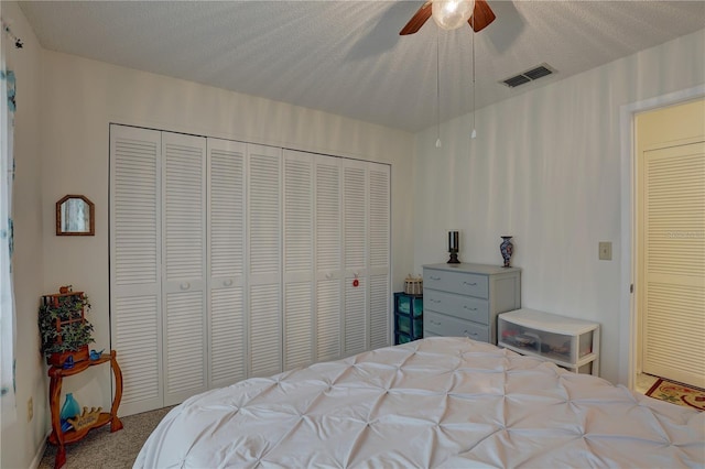 carpeted bedroom featuring a textured ceiling, ceiling fan, and a closet