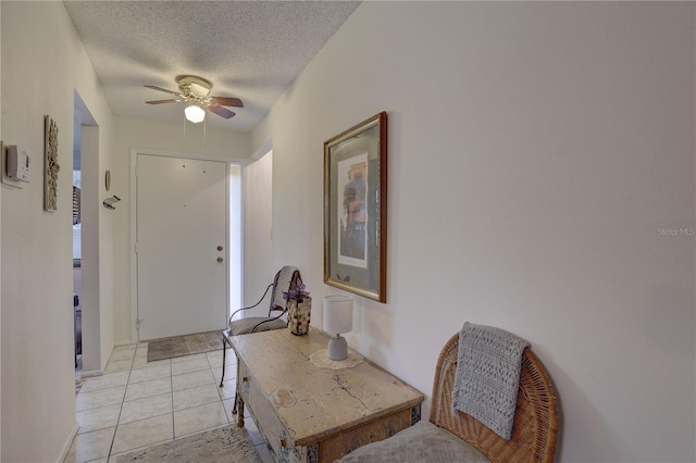 tiled foyer featuring ceiling fan and a textured ceiling