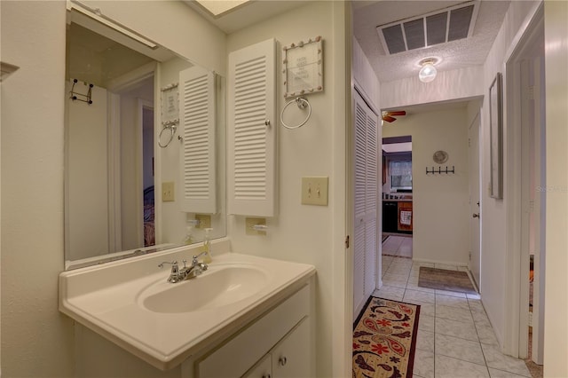 bathroom featuring tile patterned flooring, vanity, and a textured ceiling