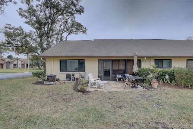 back of house with a patio and a lawn