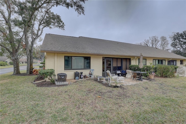 back of property with a yard and a patio