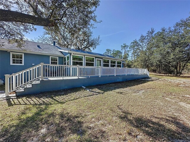 rear view of house with a sunroom and stucco siding