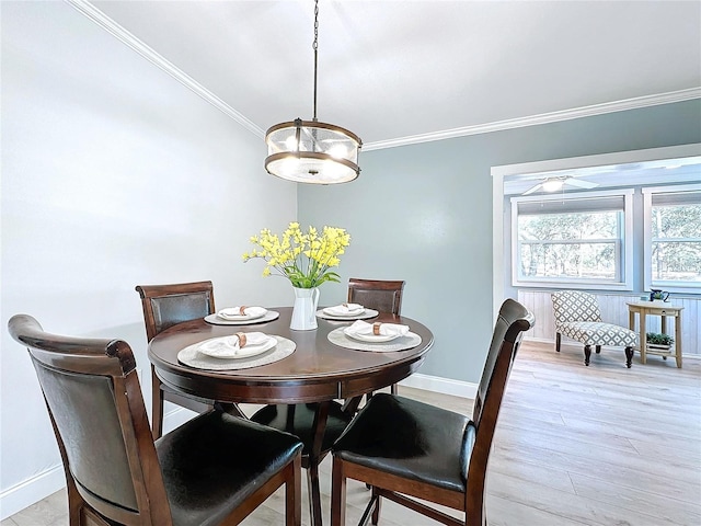 dining area with light hardwood / wood-style flooring and ornamental molding