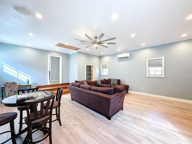 living room featuring ceiling fan, light hardwood / wood-style flooring, ornamental molding, and a wall mounted AC