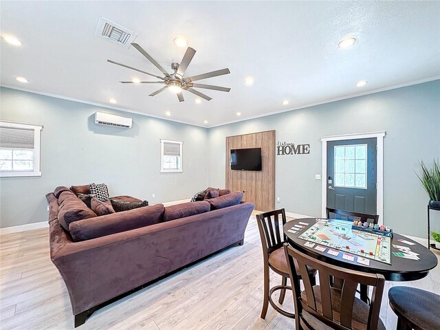 living room with crown molding, an AC wall unit, ceiling fan, and light hardwood / wood-style flooring