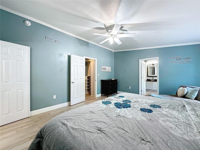 bedroom featuring ornamental molding, connected bathroom, ceiling fan, and light wood-type flooring