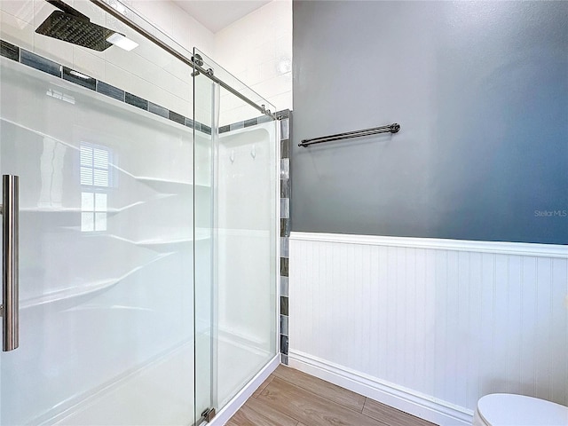 bathroom featuring hardwood / wood-style flooring, toilet, and walk in shower