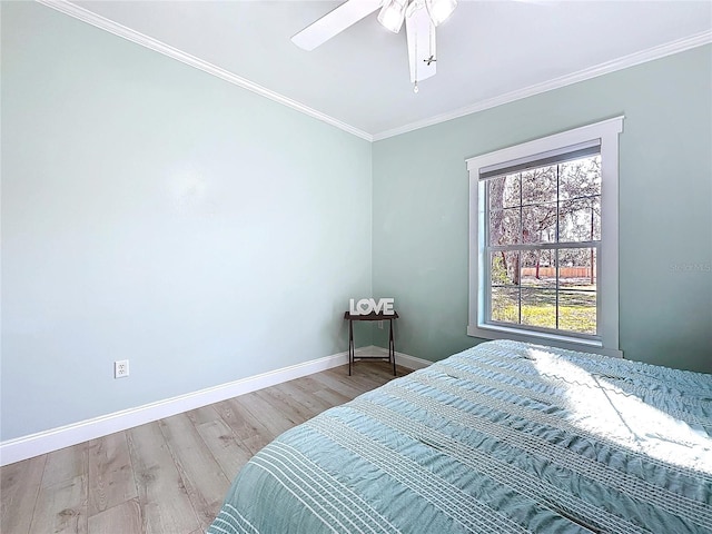 bedroom with baseboards, wood finished floors, a ceiling fan, and crown molding