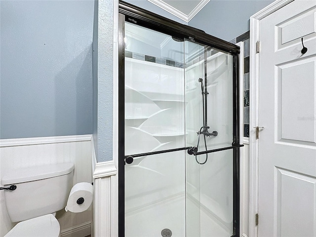 bathroom featuring an enclosed shower, ornamental molding, and toilet