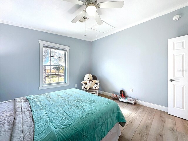 bedroom featuring crown molding, visible vents, attic access, wood finished floors, and baseboards