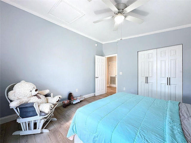 bedroom featuring attic access, ornamental molding, baseboards, and wood finished floors