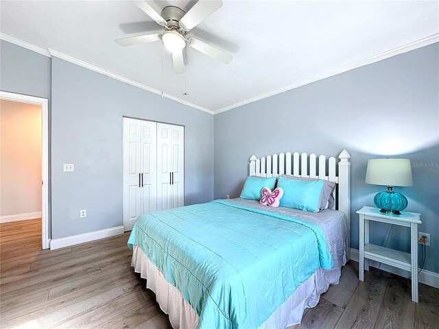 bedroom featuring baseboards, wood finished floors, and crown molding