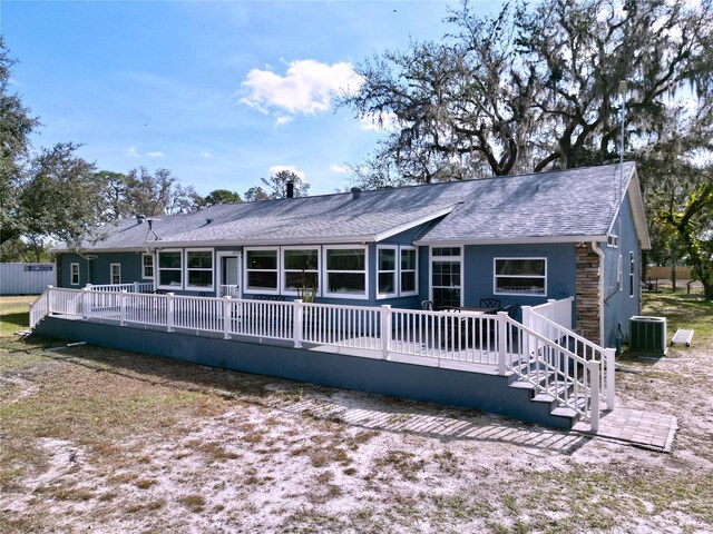 back of house featuring cooling unit, roof with shingles, and a wooden deck