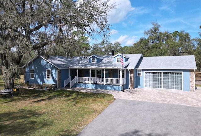 view of front facade with a garage, aphalt driveway, a porch, and a front yard