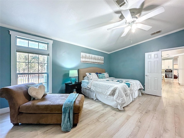 bedroom with light wood-style flooring, visible vents, and crown molding