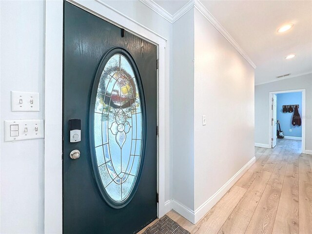 entryway featuring crown molding and light hardwood / wood-style flooring