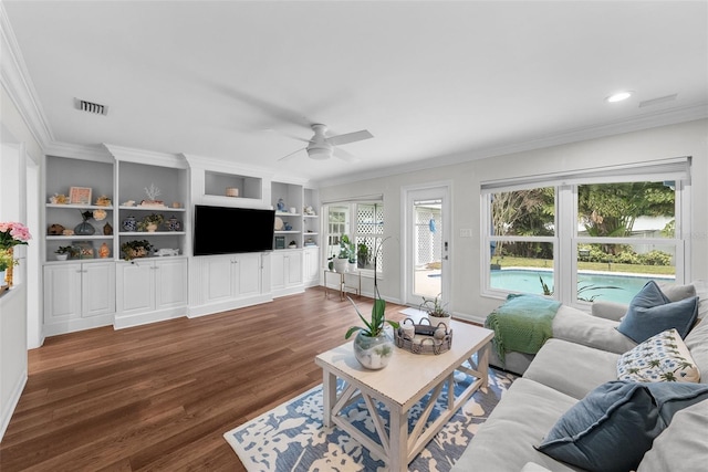 living room with ornamental molding, ceiling fan, dark hardwood / wood-style flooring, and built in shelves