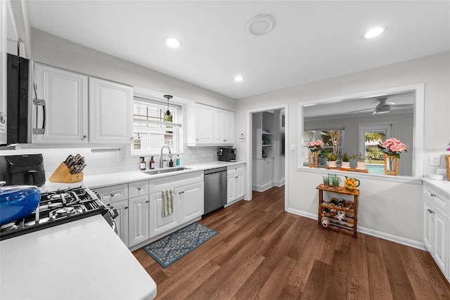 kitchen with sink, tasteful backsplash, pendant lighting, stainless steel appliances, and white cabinets