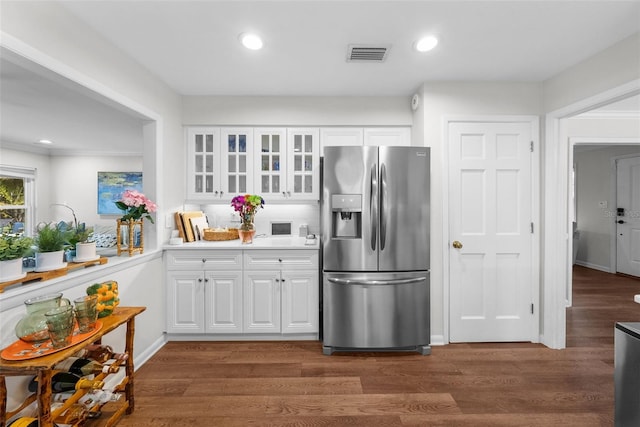 kitchen featuring stainless steel refrigerator with ice dispenser, white cabinets, dark hardwood / wood-style flooring, and decorative backsplash