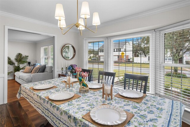 dining space with ornamental molding, plenty of natural light, dark wood-type flooring, and an inviting chandelier