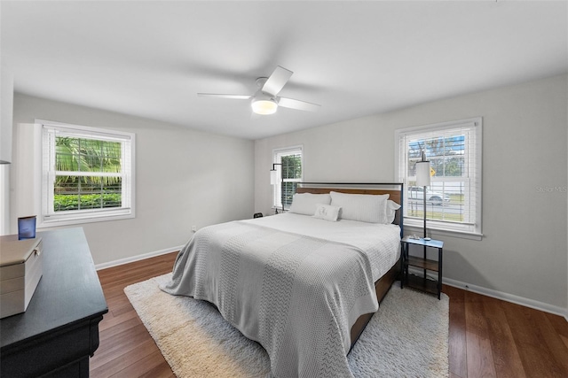 bedroom with dark hardwood / wood-style flooring and ceiling fan