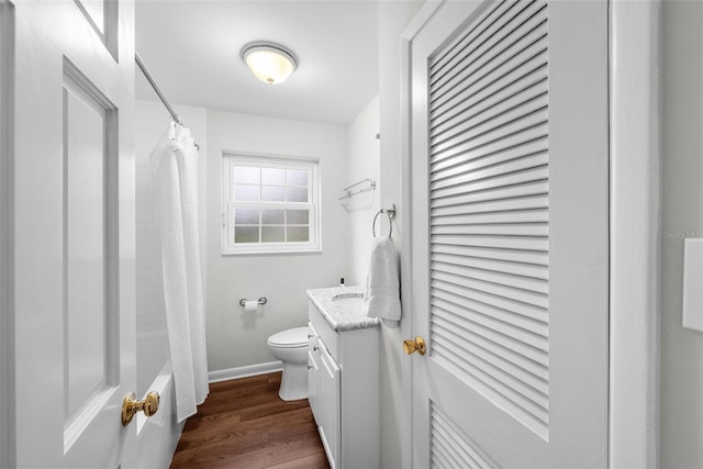 full bathroom with vanity, wood-type flooring, shower / bath combination with curtain, and toilet