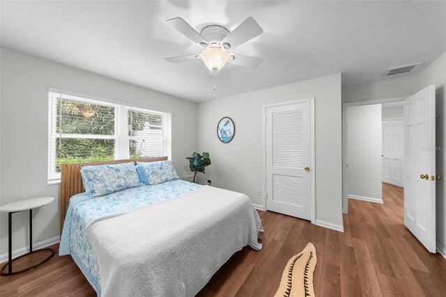 bedroom featuring hardwood / wood-style flooring, ceiling fan, and a closet